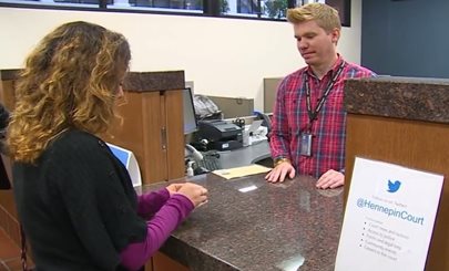 Image of a clerk at a public counter with a court user approaching